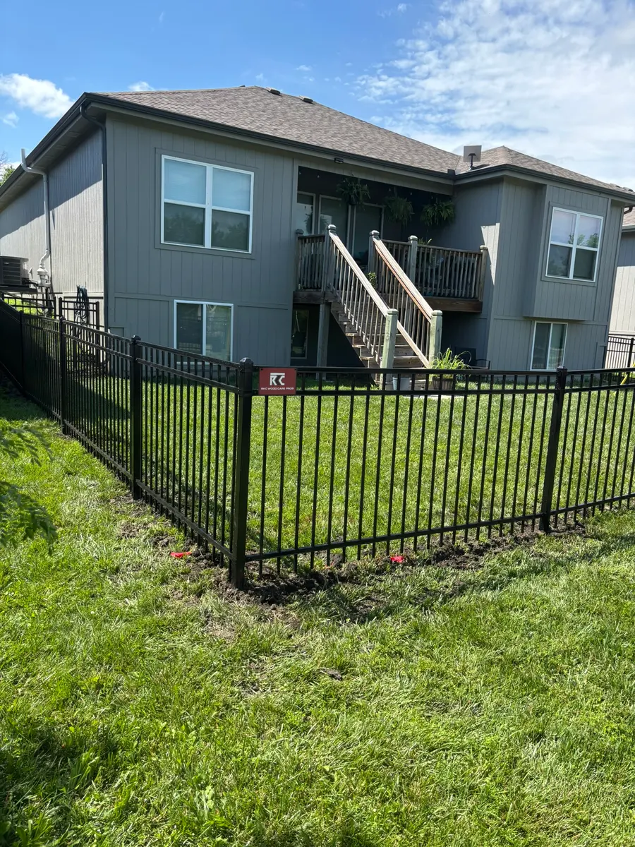 Flat-top black aluminum fence around a walk-out backyard by RKC Wood Care Pros