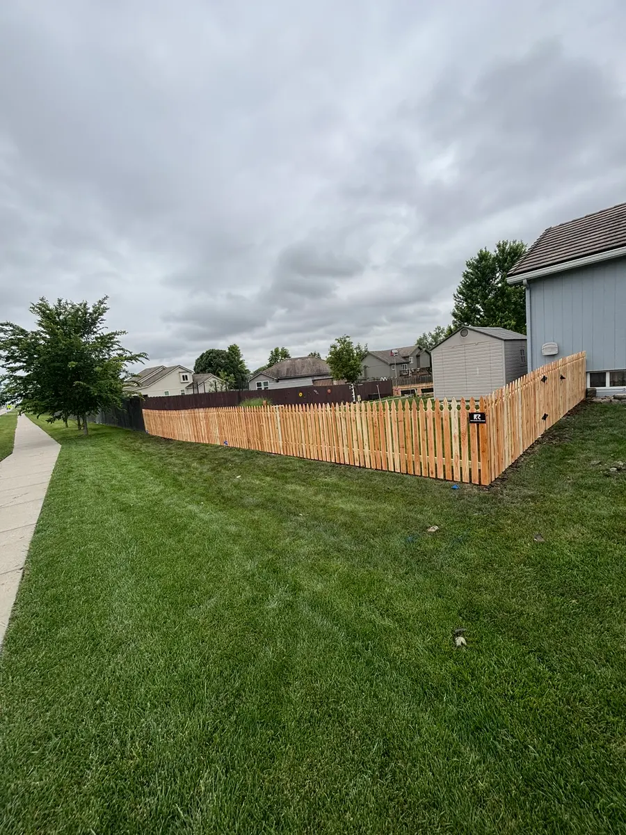 Cedar picket fence wrapping a corner lot in the Kansas City metro by RKC Wood Care Pros