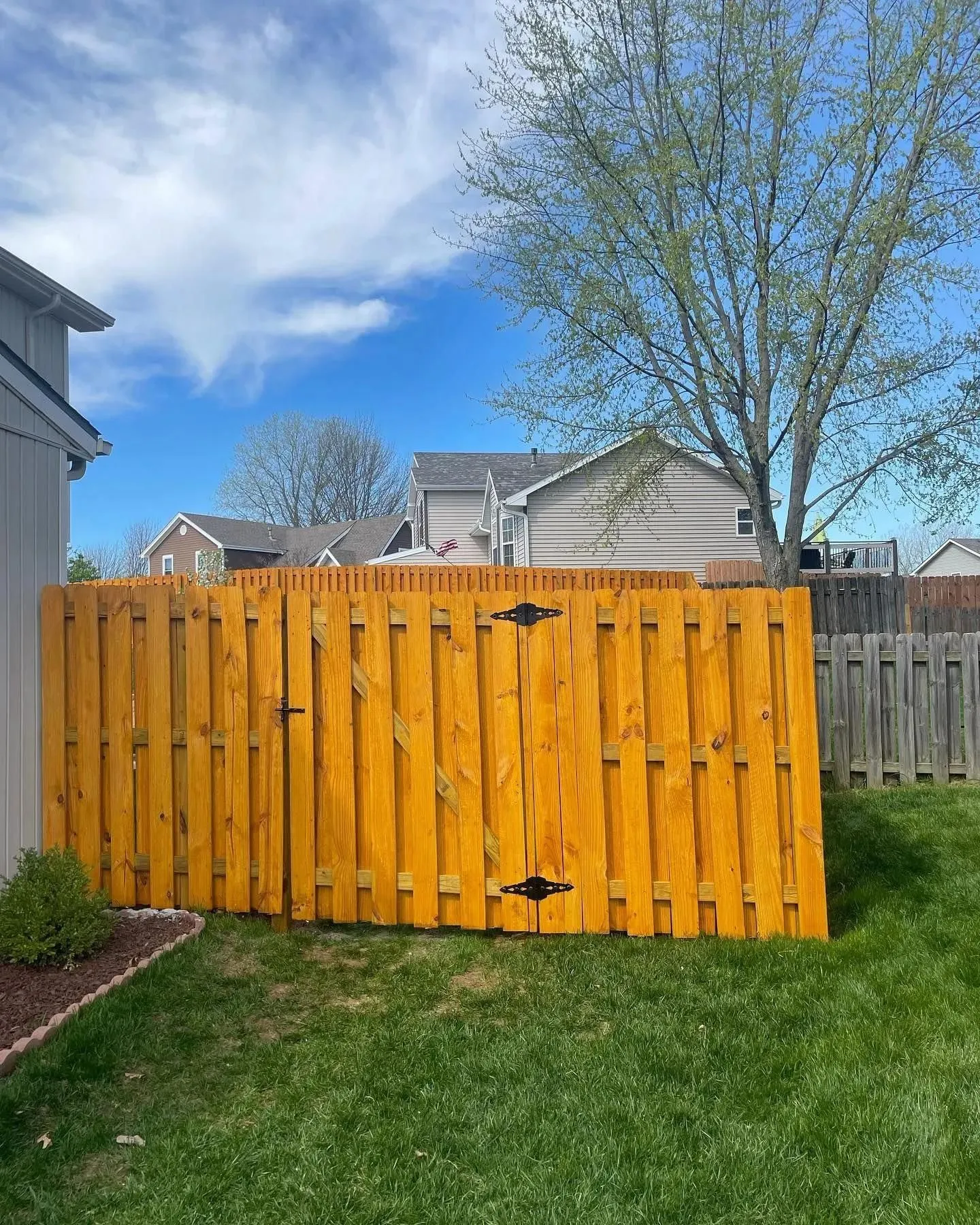 Automated wood drive gate with swing opener in Lenexa, KS by RKC Wood Care Pros