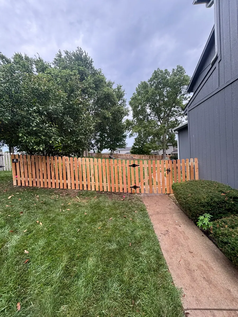 Cedar shadow box fence with a walk gate beside a front walkway by RKC Wood Care Pros