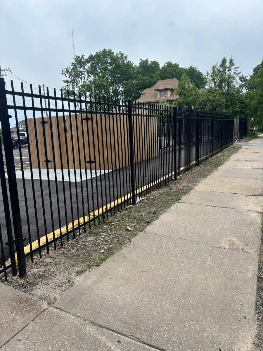 Tall spear-top ornamental iron security fence along a commercial sidewalk by RKC Wood Care Pros