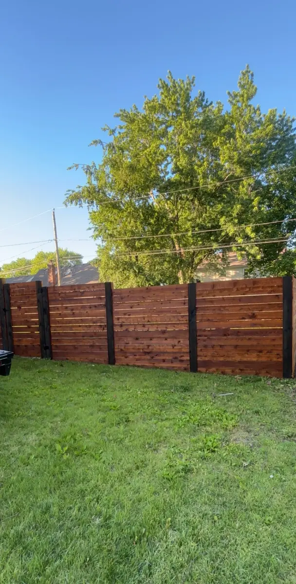 Horizontal cedar privacy fence finished in a deep mahogany stain by RKC Wood Care Pros