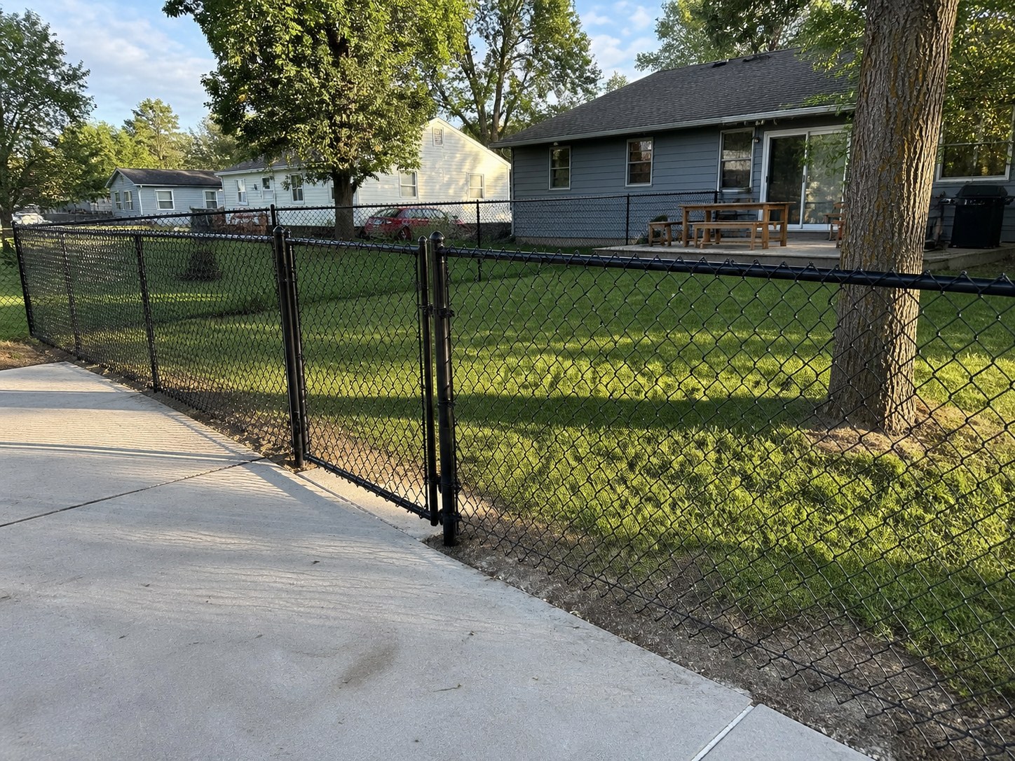 Residential chain link fence with bottom tension wire securing a Kansas City backyard — RKC Wood Care Pros