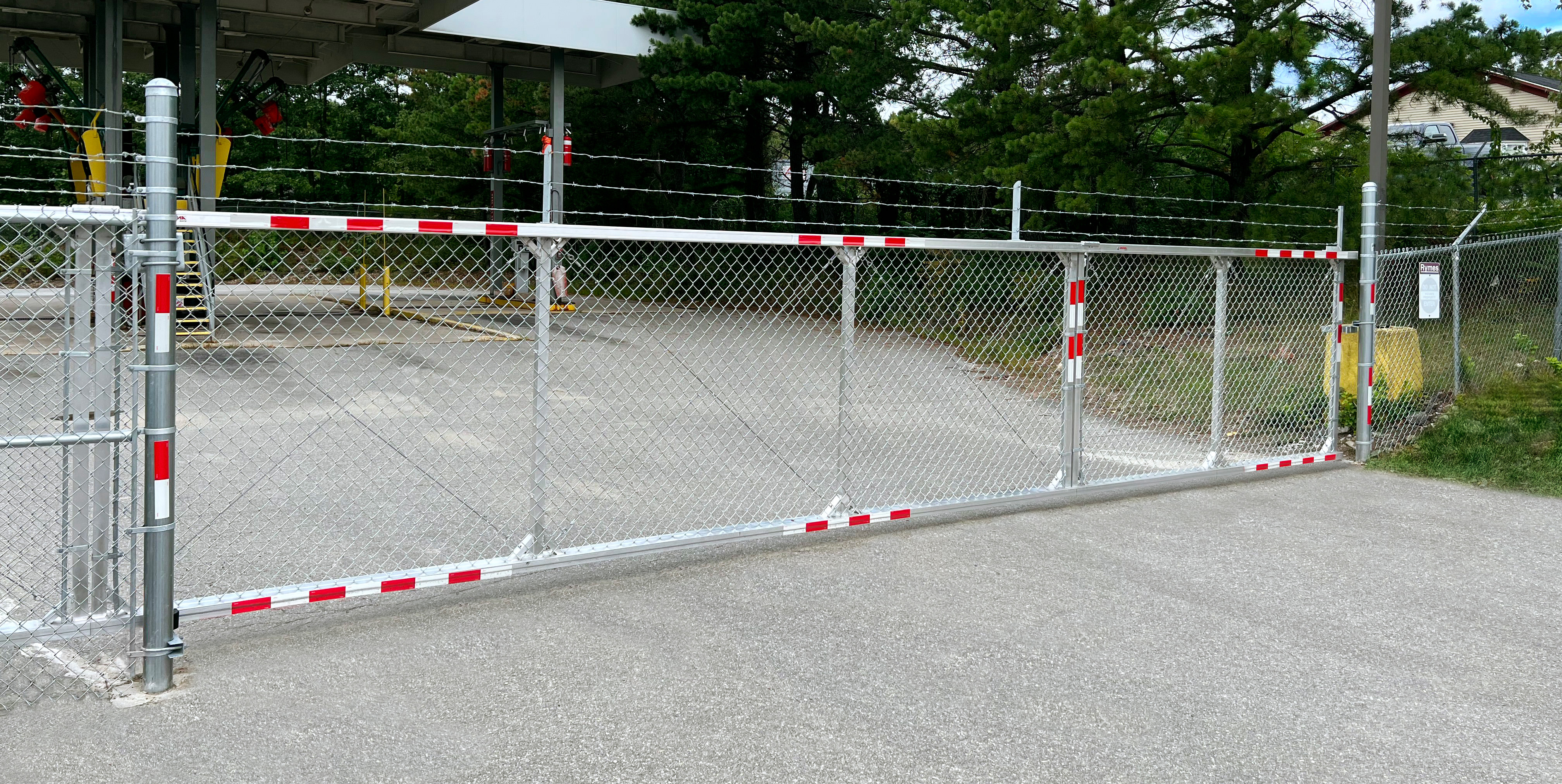 Galvanized chain link cantilever slide gate with reflective tape at a Kansas City commercial facility — RKC Wood Care Pros
