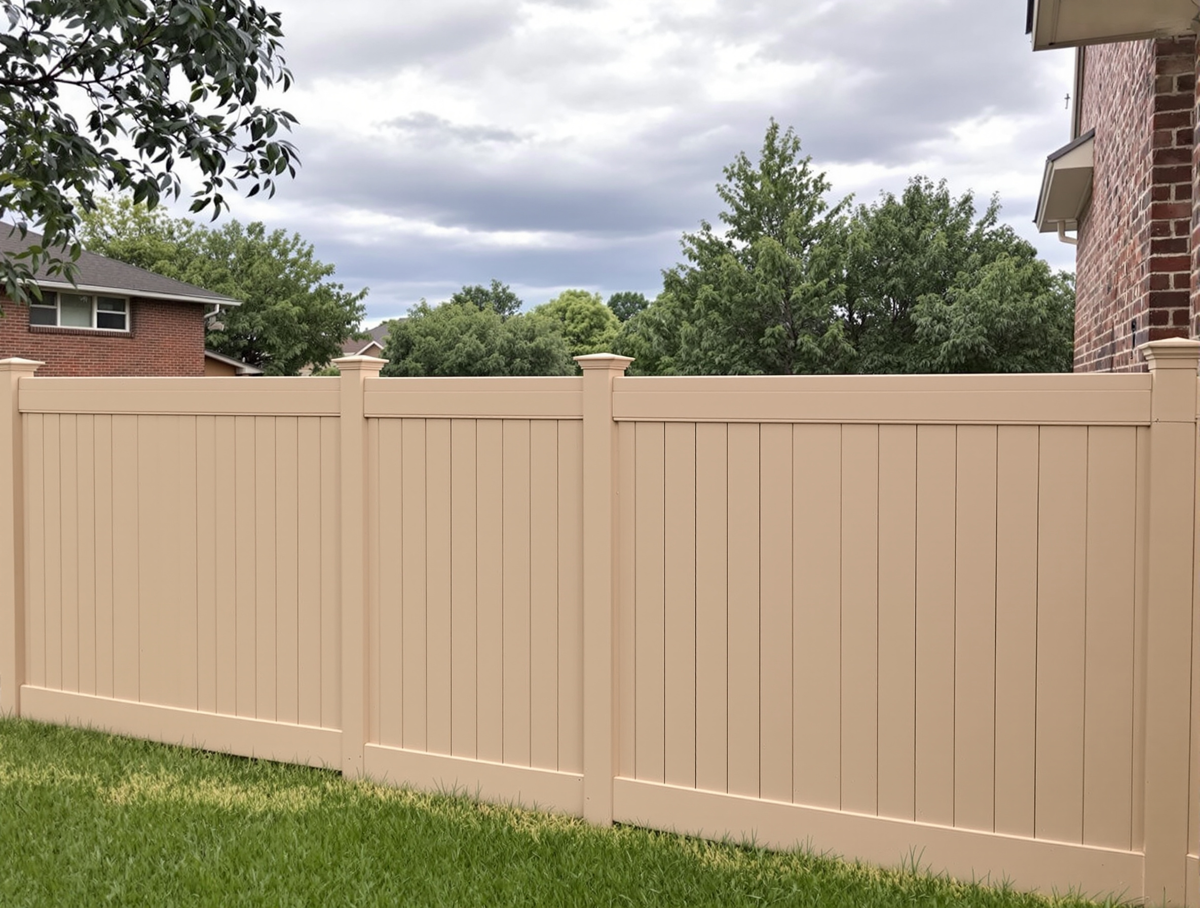 Tan tongue-and-groove vinyl privacy fence in an afternoon-lit Kansas City backyard — RKC Wood Care Pros