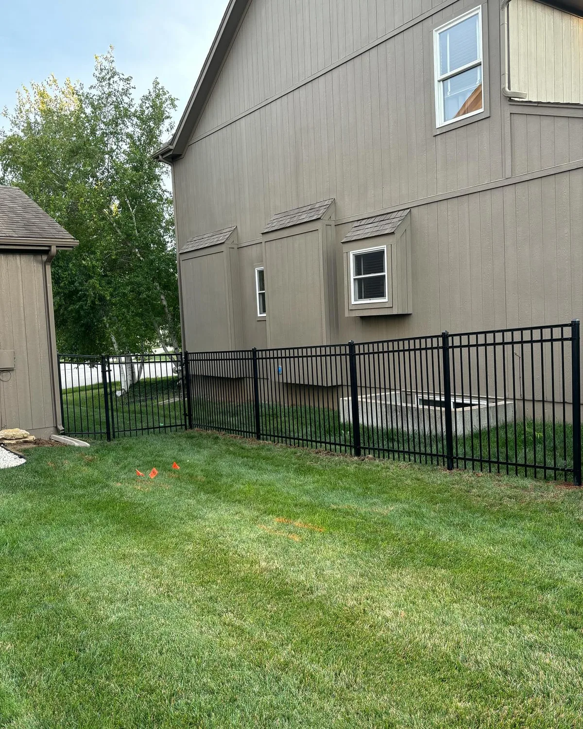 Angled view of black aluminum fence corner post in Leawood, KS backyard