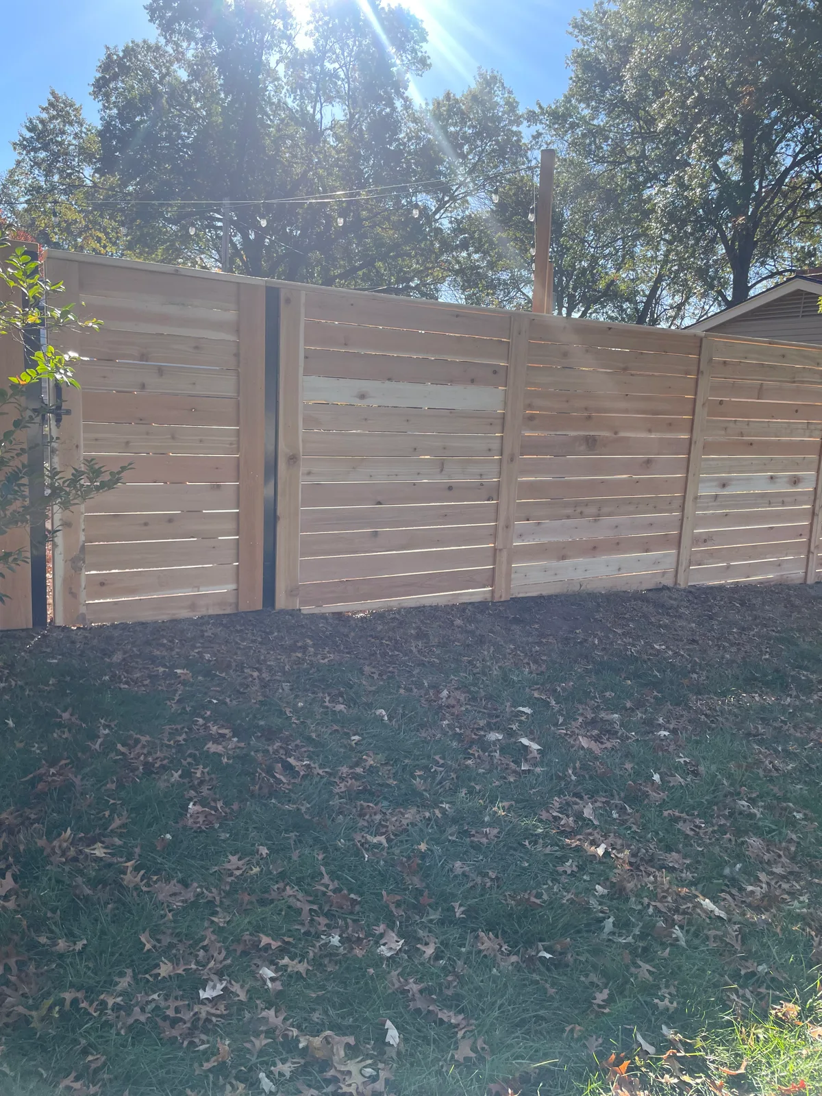 Walk gate detail and fence line on Mission, KS residential install — cedar boards freshly set