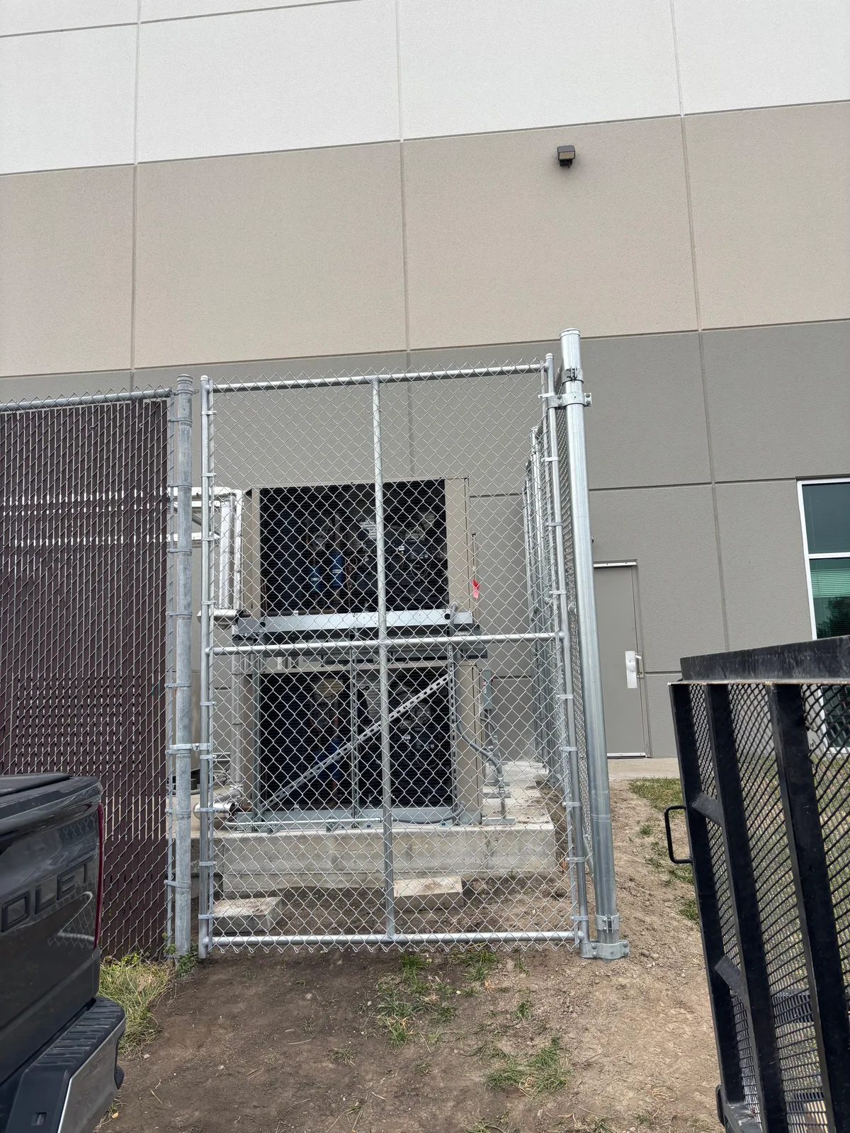 Side view of chain link utility fence panel around exterior equipment in Raymore, MO