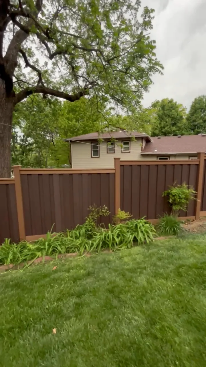 Brown Trex composite fence behind planting beds in a Prairie Village, KS backyard — RKC Wood Care Pros