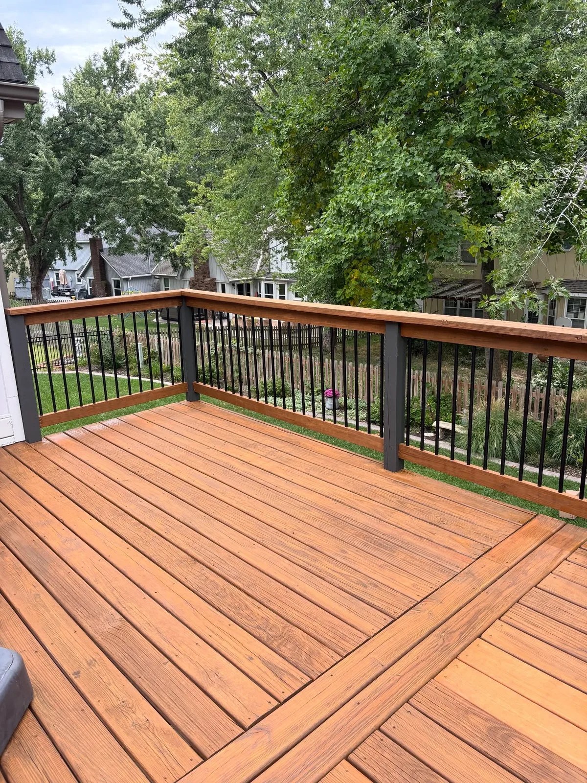 View down the full L-shaped deck from upper corner in Blue Springs, MO after stain