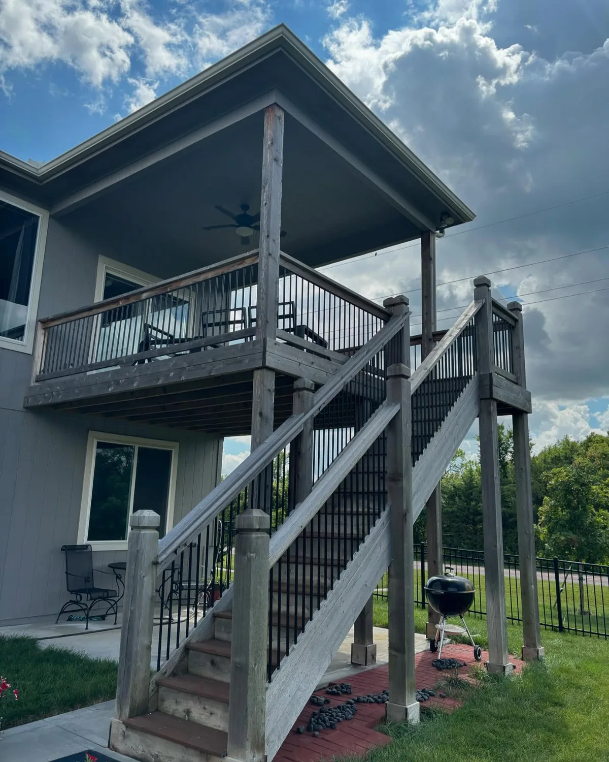 Covered porch upper level and stair system on stained elevated deck in Oak Grove, MO