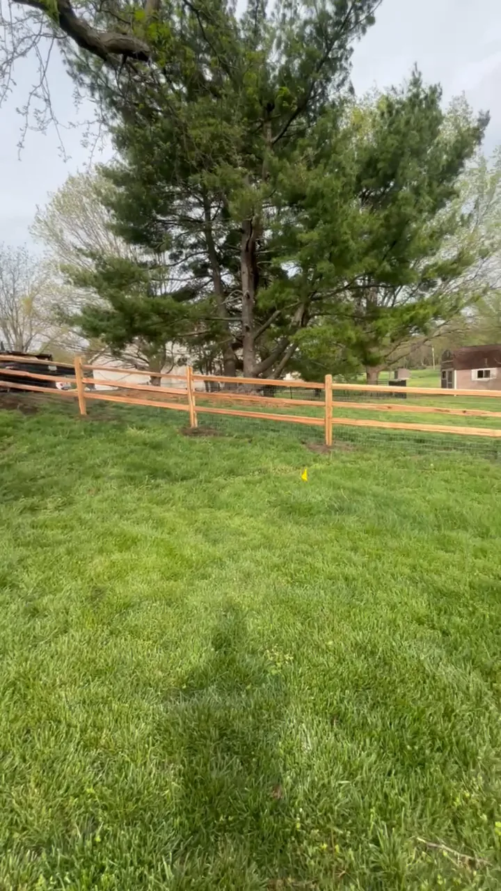 Split-rail wood farm fence with wire mesh across a large Overland Park, KS lawn — RKC Wood Care Pros