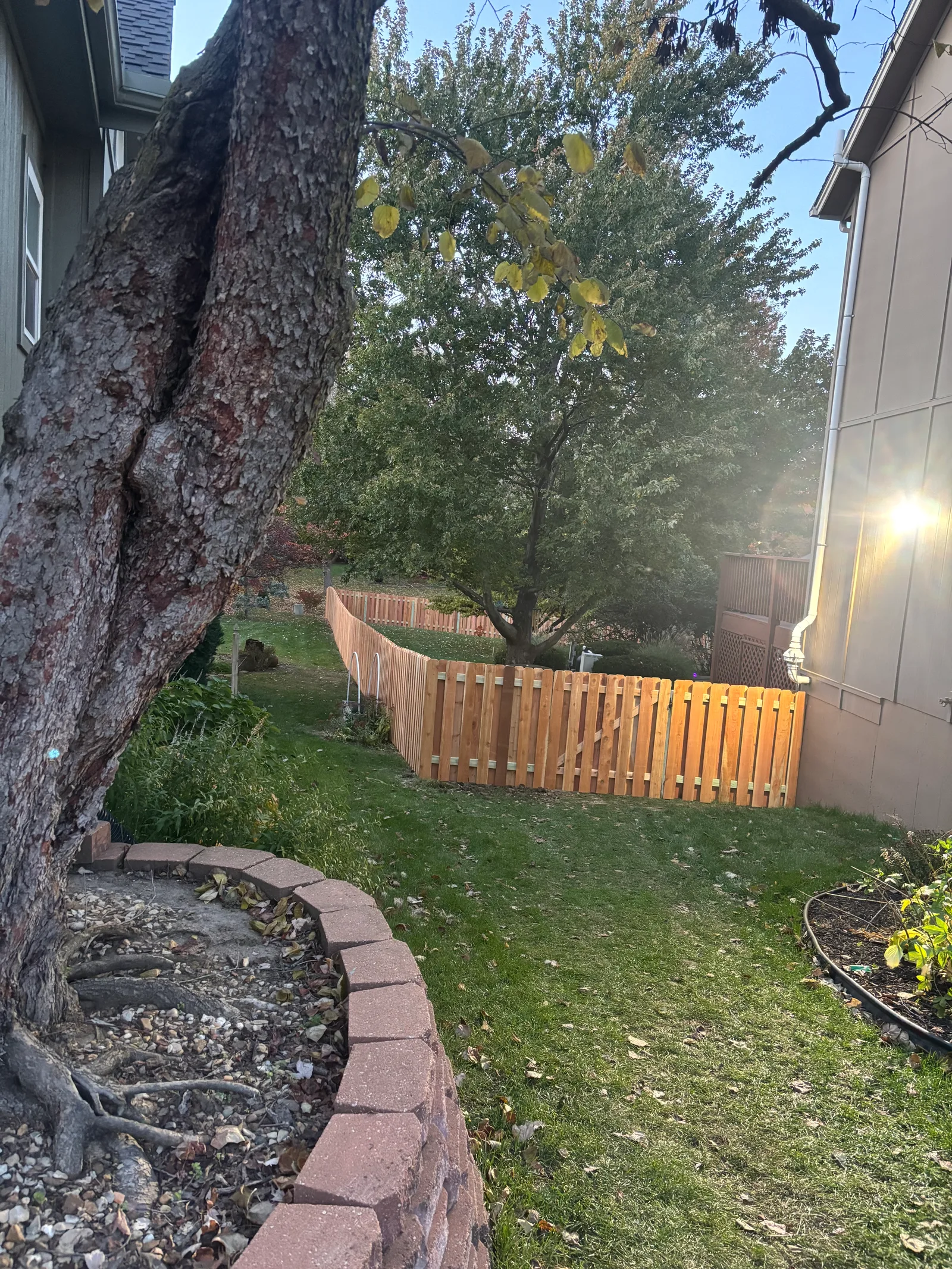 New horizontal cedar slat fence in afternoon sunlight in Gardner, KS — long perspective view