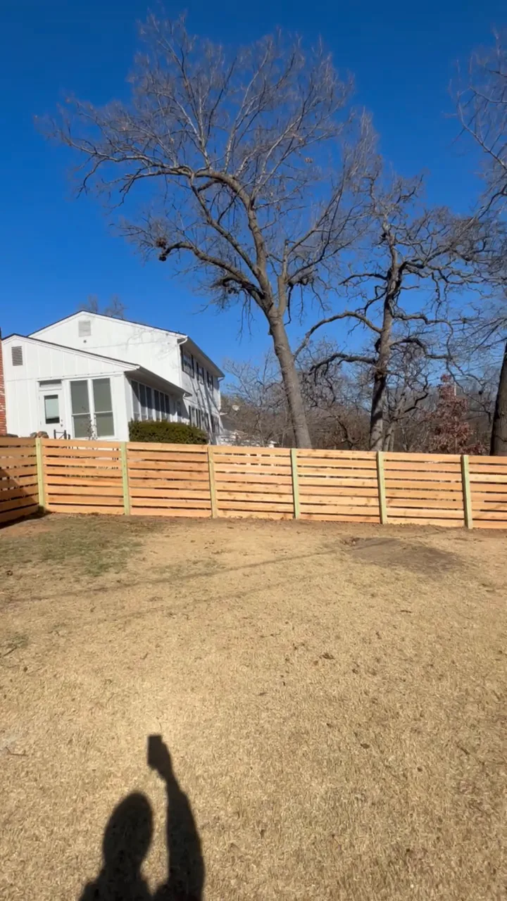 Horizontal slat wood fence around a sloped backyard in Bonner Springs, KS — RKC Wood Care Pros